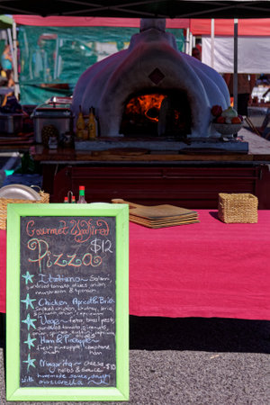 Motueka, Tasman/New Zealand - January 27, 2013: Motueka Sunday market stall making homemade pizzas. A blackboard menu.のeditorial素材