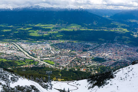 City of Innsbruck, Austria from the top of a mountain  Snowcapped mountains in the distance の写真素材