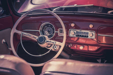 Close-up, detailed photo of the interior, dashboard, steering wheel and speedometer of a classic oldtimer luxury sports car.の写真素材