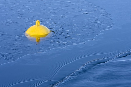 A bouy in ice sheet illuminated by the setting sun.の写真素材