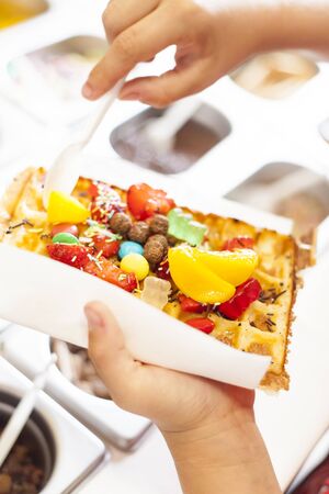 Waffle with fruit and candy, applying different toppings の写真素材