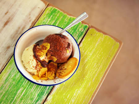Tasty chocolate and vanilla ice cream on the wooden table