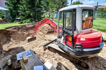 A family house is being rebuilt with the help of an excavator