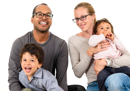 Happy interracial family is celebrating, laughing and having fun with Hispanic African American Father, Caucasian mother and Mulatto children son and daughter.  Isolated on white.の写真素材
