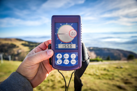 Paraglider is checking Digital altimeter for paragliding or parachute before the start on the slope