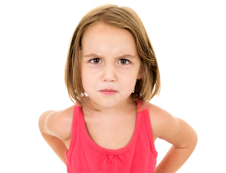Little girl is angry, mad and looking at the camera. Emotion face.