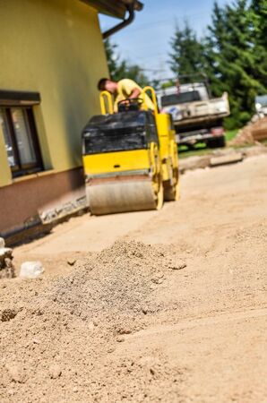 Making and constructing a new asphalt road with a roller and the sand. The sand stage of...