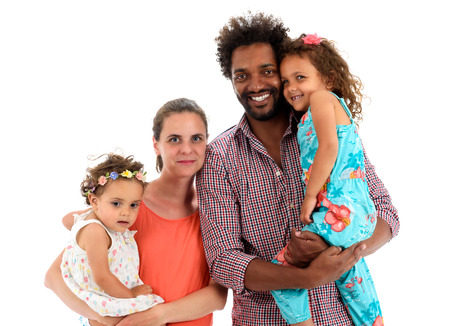 Happy interracial family is celebrating, laughing and having fun with Hispanic African American Father, Caucasian mother and Mulatto children daughters.  Isolated on white.の写真素材