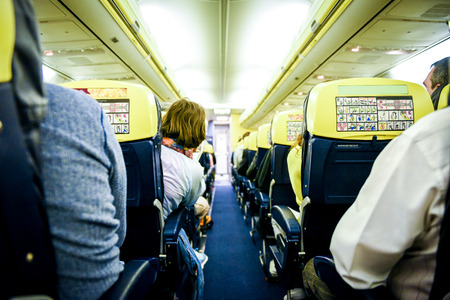 People sitting in commercial aircraft. Rows of sits on a low cost airlines passenger jet plane.の写真素材