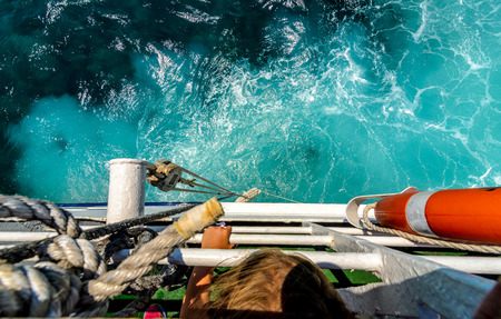 Starboard side of a ferry boat on the Adriatic Sea. The wake from a giant ship cruising through the blue ocean and clear skies.の写真素材