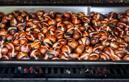 Roasting grilled Chestnuts on barbecue with flames, fire and charcoal. Homemade roasted chestnuts are prepared in BBQ grill fireplace.の写真素材