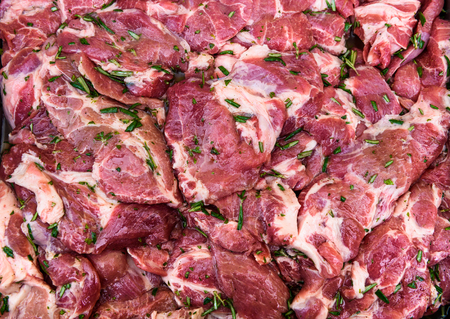 Raw pork neck chops meat with spices ready for barbecue. BBQ uncooked fresh slices of beef steaks -...