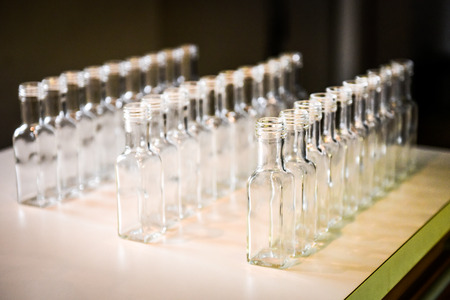 Set of small transparent plastic bottles ready to be filled. Filling bottles in domestic kitchen.の写真素材