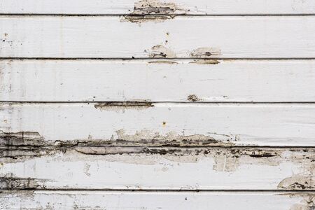 Dirty, old weathered white outside wooden plank wall. Outdoor flooring with old paint and rain marks - decaying wooden flooring.の写真素材