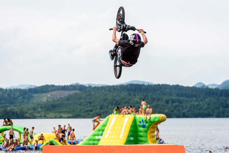 Velenje, Slovenia - June 24, 2017: Pljusk na Velenjski plazi extreme sports lake jumping competition event. Different extreme activities including slip and slide, bike, skate and roller ramp jumping in the lake.のeditorial素材