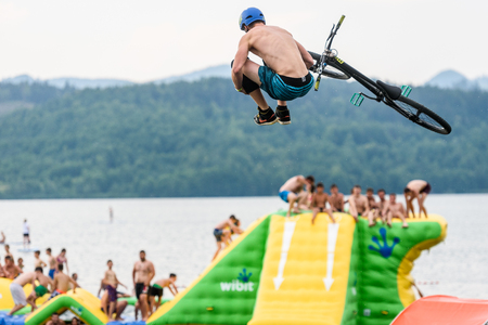 Velenje, Slovenia - June 24, 2017: Pljusk na Velenjski plazi extreme sports lake jumping competition event. Different extreme activities including slip and slide, bike, skate and roller ramp jumping in the lake.のeditorial素材
