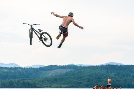 Velenje, Slovenia - June 24, 2017: Pljusk na Velenjski plazi extreme sports lake jumping competition event. Different extreme activities including slip and slide, bike, skate and roller ramp jumping in the lake.のeditorial素材