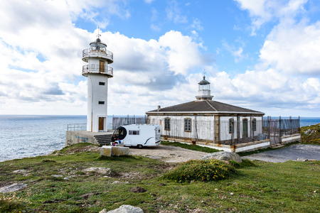 CABO TOURINAN, SPAIN - MAY 17, 2017: Tourists with RV motorhome camper at Cabo Tourinan - the most western point of Spain with lighthouse. Popular tourist and pilgrim destination.  Beautiful old lighthouse on rocky cliff and Atlantic ocean in Spain.のeditorial素材
