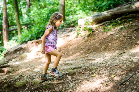 Children - twin girls are hiking in the mountains. Active family, parents and children mountaineering in the nature.の写真素材