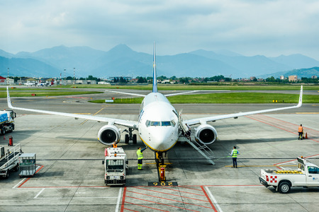Milano, Italy - MAY 10, 2017: Resupplying and servicing Ryanair plane for flight from Milano Italy to Santiago de Compostela Spain on a sunny day. Terminal with Ryanair planes. Ryanair is biggest budget low-cost airline in the world.のeditorial素材