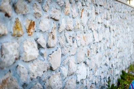 Stone rock fence or gabion and road or footpath. Old built rock wall cement structure in a Mediterranean town in Croatia.の写真素材