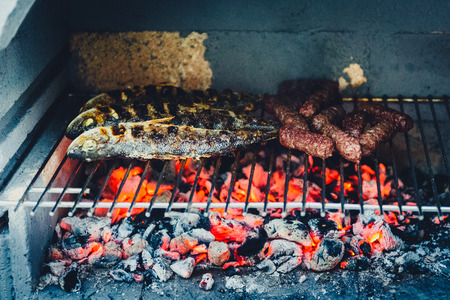 Barbecue in built barbecue grill fireplace with fish and chevaps. Concrete bbq fireplace back yard fireplace in Croatia.の写真素材