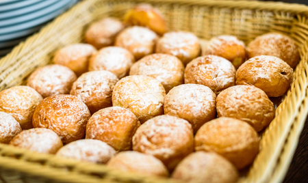 Fresh Doughnuts or Donuts in a basket in buffet line. Delicious sweet pastry as a part of continental breakfast. Catering food service at business event.の写真素材
