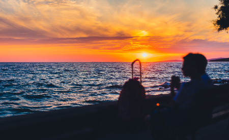 Amazing golden summer sunset in Adriatic sea, Silba, Croatia. Silhuete of intentionally out of focus people watching and enjoying beautiful sunset over the ocean.の写真素材