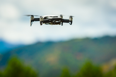 Drone quadcopter UAV with digital camera flying in the sky. Professional unmanned aerial vehicle...