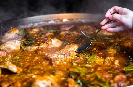 Cooking and making a traditional Spanish Paella over open fire. Traditional way of preparing...