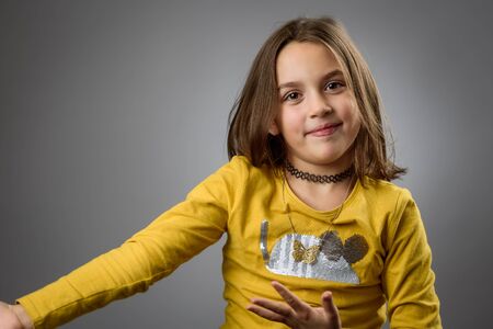 Portrait of happy young little girl with emotions on gray. Portrait of a cheerful cute little child...