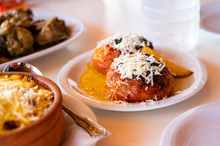 Family eating traditional Greek food in restaurant tavern in Greece. TraditionallyÂ served greek food in a greek tavern on authentic dinner tables and traditional plates. Healthy Greek food.