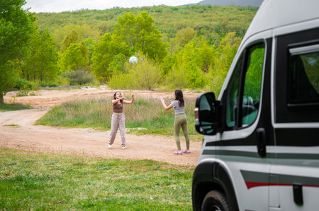 Children are playing next to parked campervan or motorhome. Wild or freecamping in Bosnia, Greece or Croatia in nature next to the lake.の写真素材