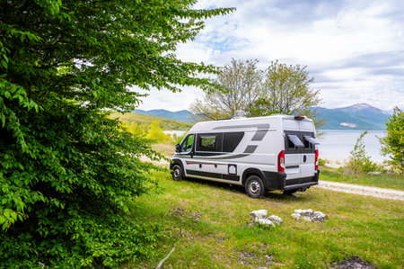 Camper van or motorhome is free camping on the side of the road on BuÅ¡ko lake, Bosnia and Herzegovina. Wild camping in Bosnia, Greece or Croatia in nature next to the lake.の写真素材