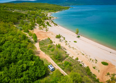 Aerial view of BuÅ¡ko lake in Bosnia and Herzegovina. ArtificialÂ lake with some motorhomes or campervansÂ free camping on the beach.の写真素材