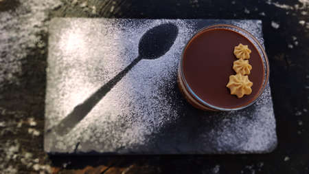 Chocolate desert with white sugar spoon.