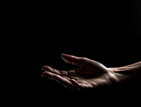 Human hand on dark background on empty space for text. Generative AI.の素材