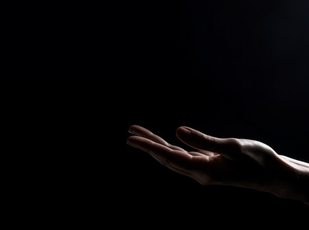 Human hand on dark background on empty space for text. Generative AI.の素材
