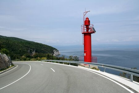 The red lighthouse on the road to the harbor Croatiaの写真素材