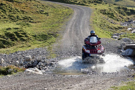 With the ATV by a mountain stream