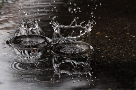 Two large drops of rain fall to the groundの写真素材