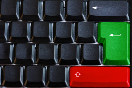 Black computer keyboard with green and red button and arrowsの写真素材
