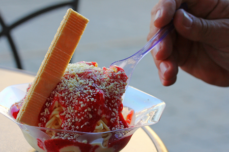 A man is eating a sundae. A man is eating a spaghetti iceの写真素材
