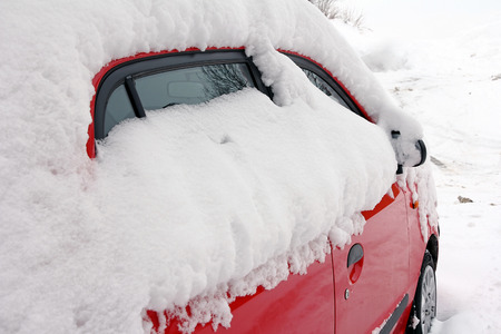 Winter in road traffic - A snowed red carの写真素材