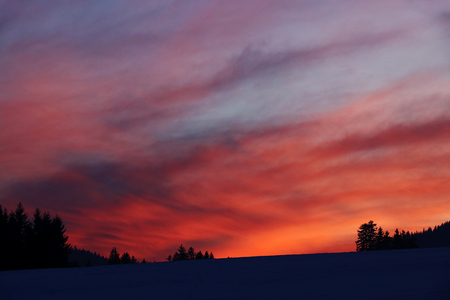 A beautiful and colorful winter sunset in Bavaria above a fieldの写真素材
