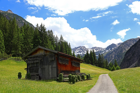 Wooden house with wooden frames for hay drying in the mountains of Austria. Wooden cabin in the mountainsのeditorial素材