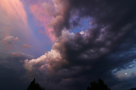 A sunset with colored and dark clouds. Sundown with thunderclouds