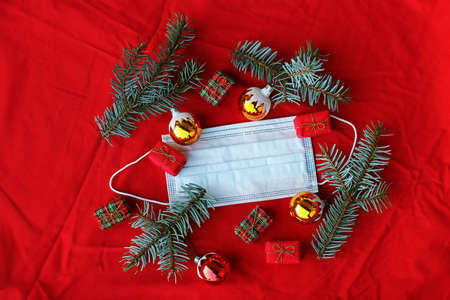 Corona and Christmas. A protective mask, Christmas tree balls, fir branches and Christmas presentsの写真素材