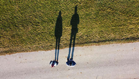 Aerial shot with drone of two people with a long shadow
