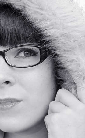 The face of a young woman with glasses and fur hoodの写真素材
